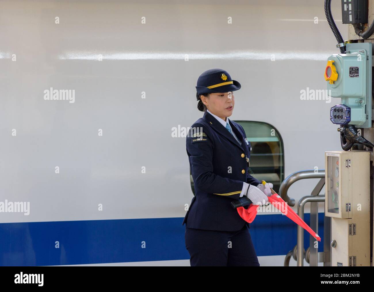 Osaka / Japon - 20 décembre 2017 : femme officier de la gare ferroviaire de Central Japan Railway Company devant le train à grande vitesse shinkansen à Shin Banque D'Images