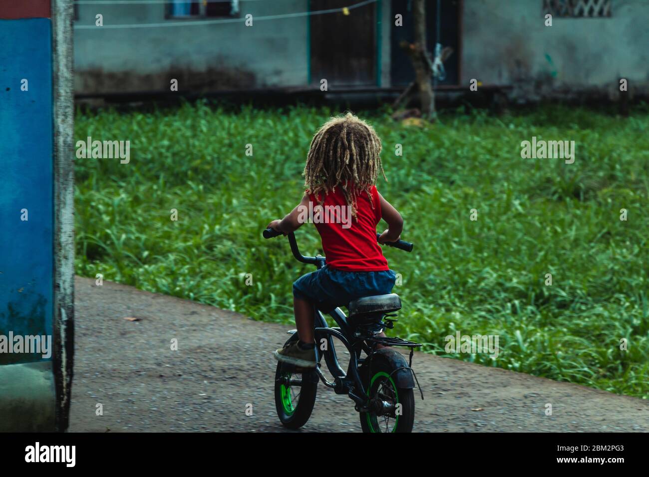 Petit garçon à vélo à Tortuguero, Costa Rica Banque D'Images