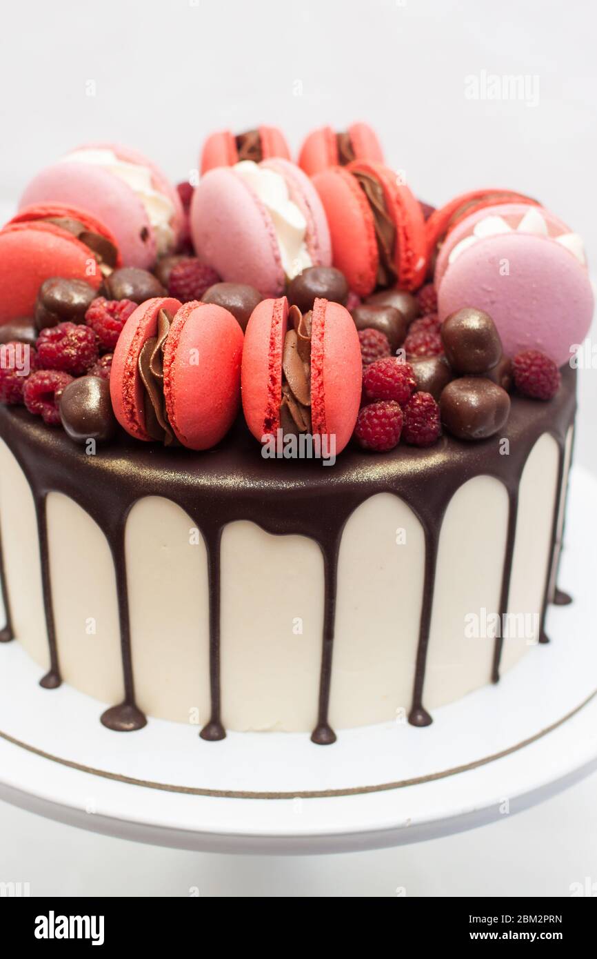 Gateau Au Chocolat Fondu Macarons Francais Rouges Et Roses Framboise Fraiche Et Truffes Au Chocolat Sur Cakestan Blanc Arriere Plan Simple Photo Stock Alamy