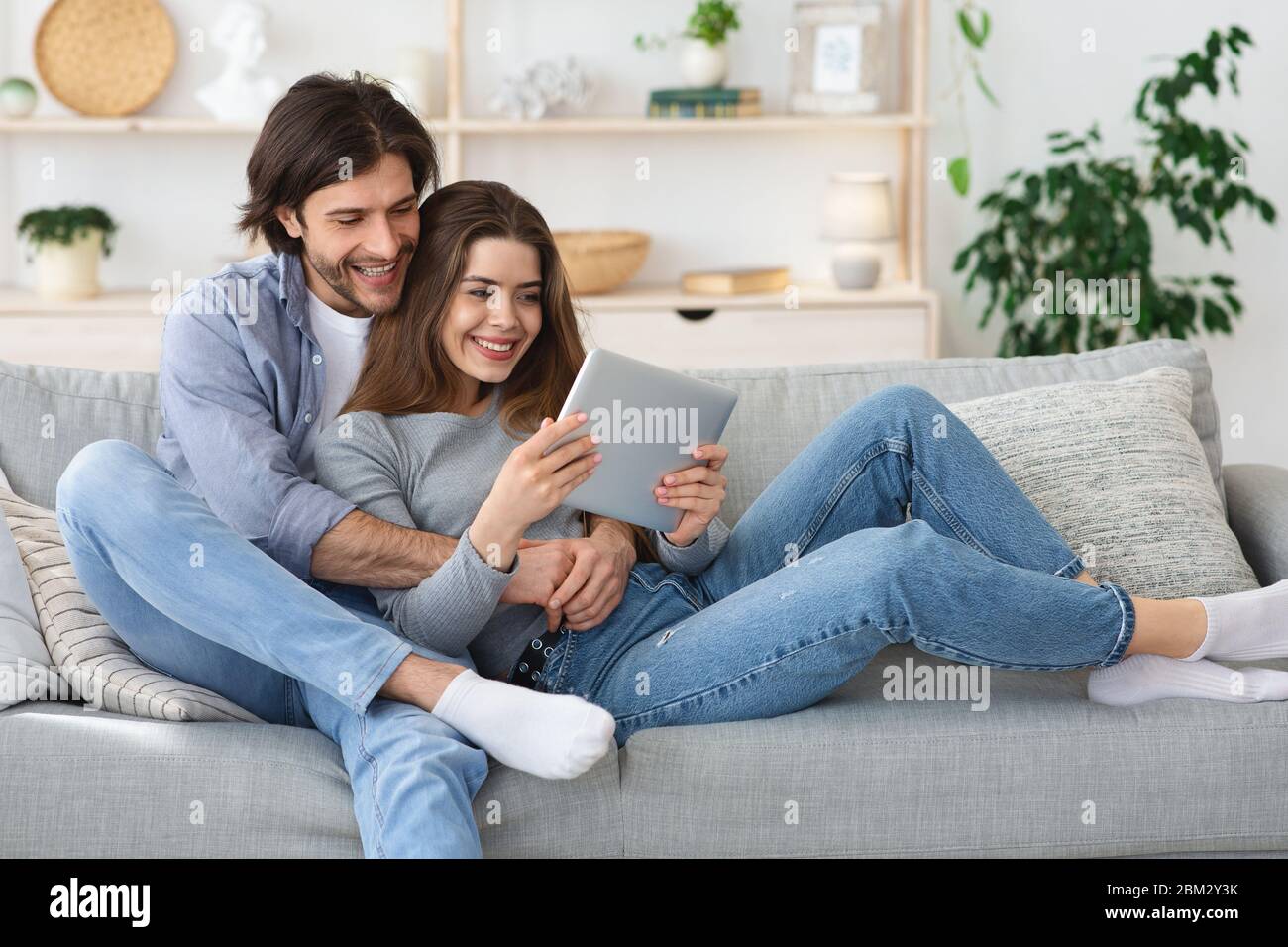 Mi Adulte Homme Utilisant Tablette Numérique Avec Écran Vide En Position  Couchée Sur Le Canapé À La Maison Banque D'Images et Photos Libres De  Droits. Image 30581011