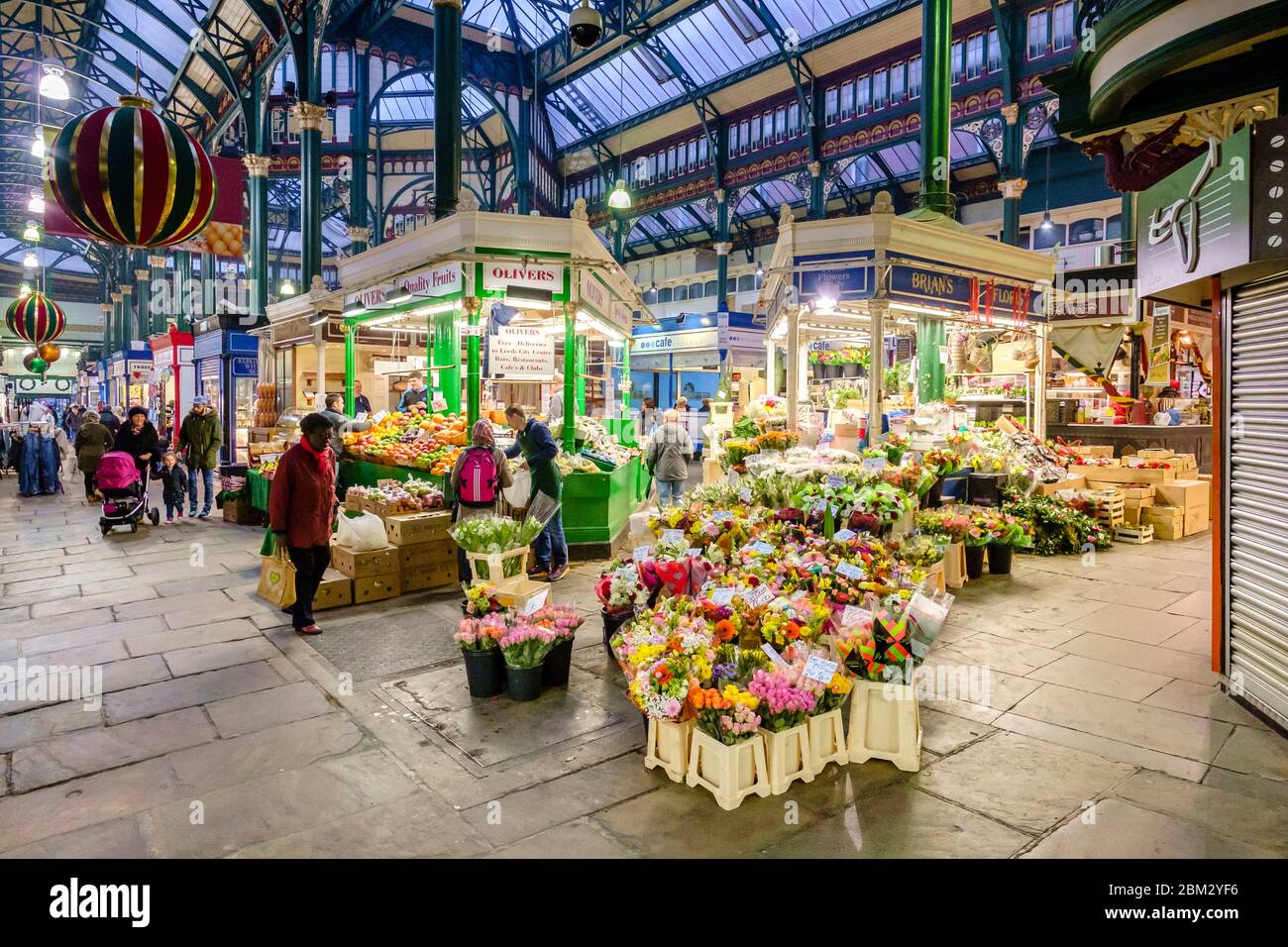 Vue intérieure du marché intérieur de Leeds Kirkgate, avec ses étals de fleurs et de légumes et son arc victorien, dont le toit en verre Banque D'Images