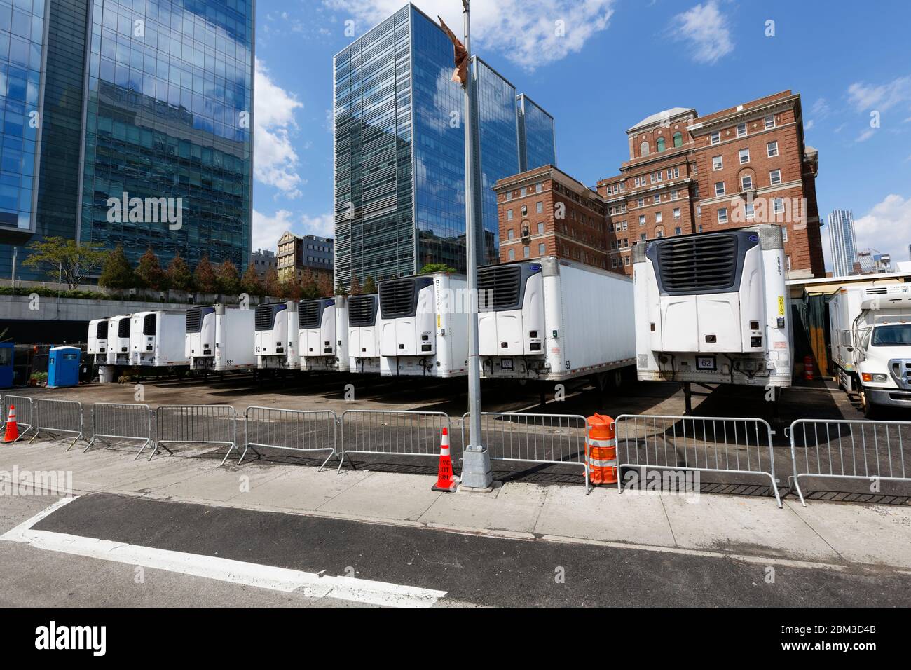 Camions frigorifiques temporaires garés derrière l'installation principale des examinateurs médicaux de New York pour les victimes de Covid-19 Banque D'Images