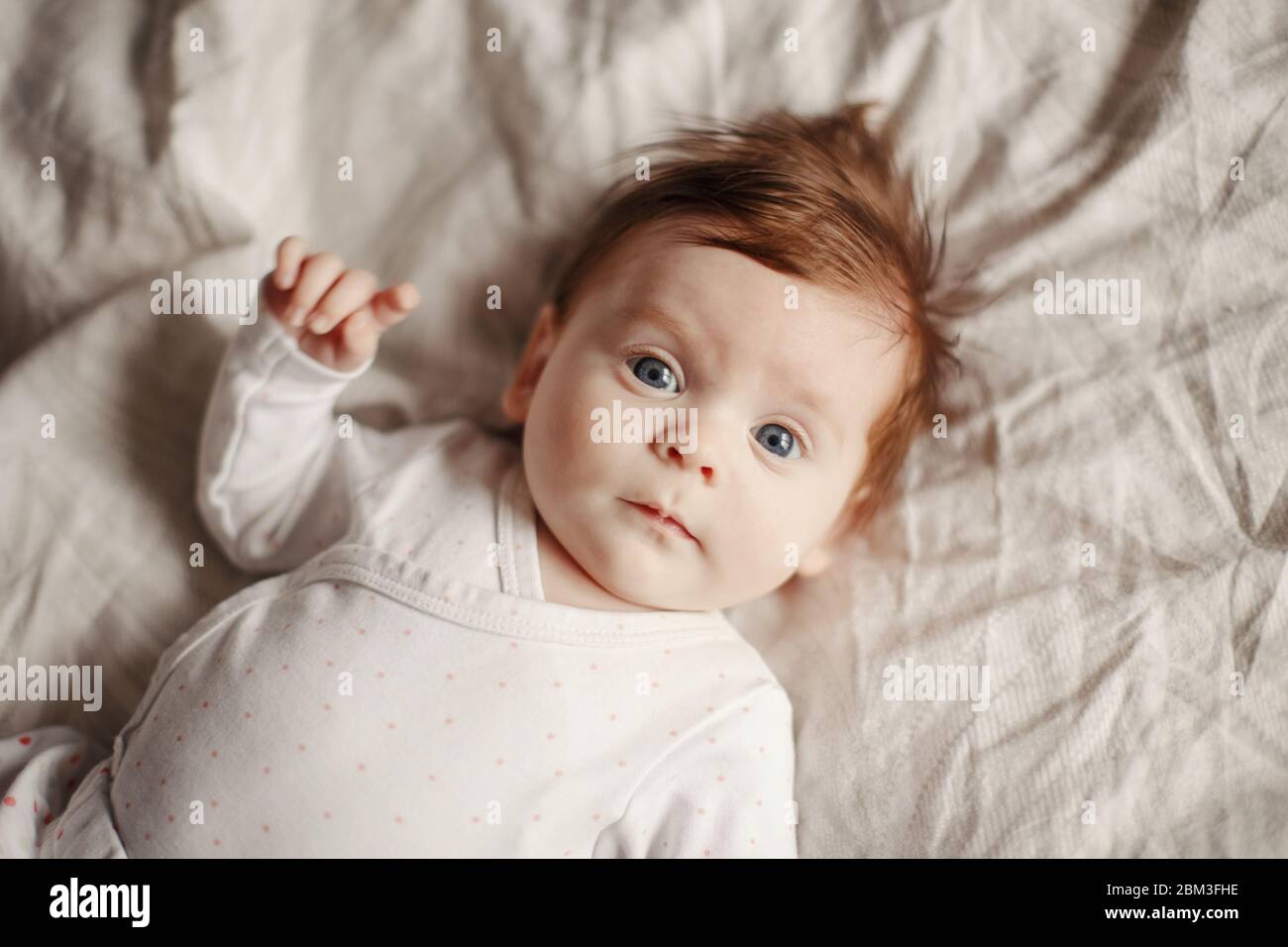 Portrait En Gros Plan De Bebe Casien Mignon Nouveau Ne Adorable Enfant Drole Avec Des Yeux Gris Bleu Et Des Cheveux Rouges Couche Sur Le Lit Regardant La Camera Photo Stock Alamy