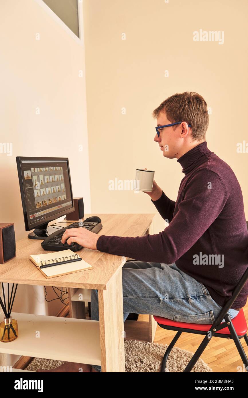 jeune blonde millénaire travaillant à l'ordinateur de boire du café à la maison Banque D'Images