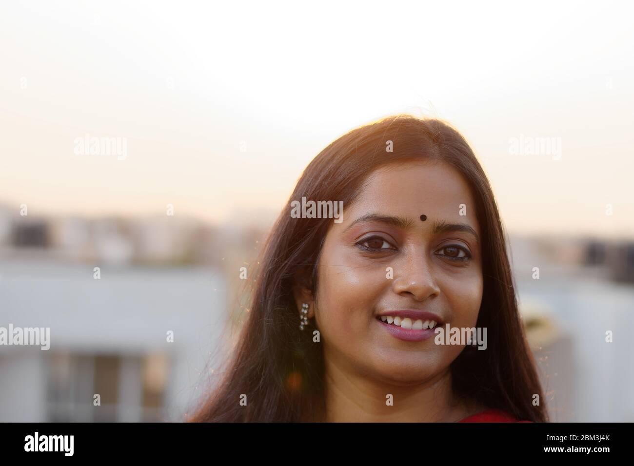 Visage Portrait d'une femme brune indienne souriant sur le toit Banque D'Images