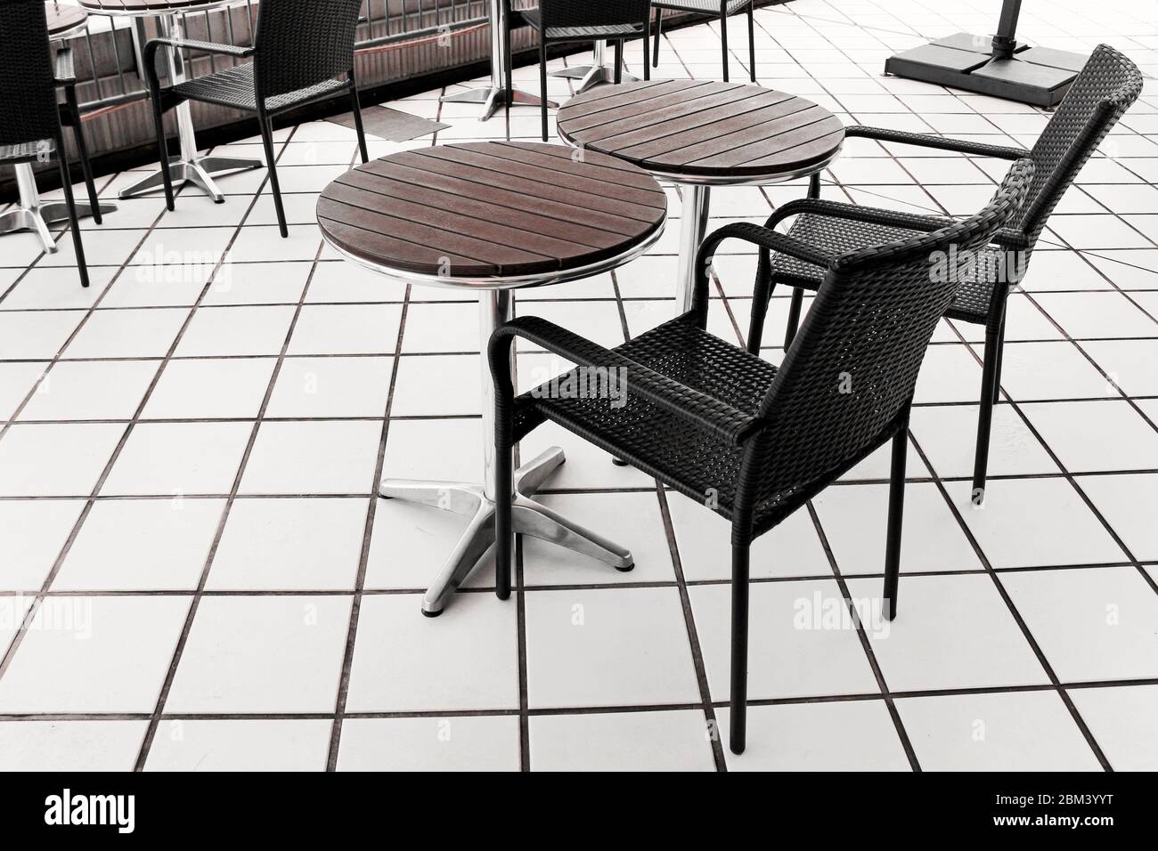 Tables et chaises au décor simple et moderne sur une terrasse carrelée de blanc Banque D'Images