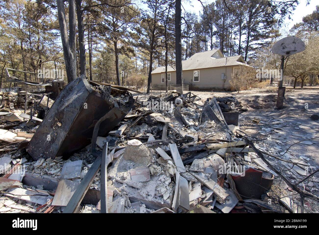 Bastrop County Texas USA, 9 septembre 2011: Une maison est intacte tandis que le garage à côté de lui se trouve dans les ruines de l'autoroute 21 après un feu de forêt a traversé les forêts de piney dans le comté de Bastrop 30 miles à l'est d'Austin. Les incendies ont détruit 1 400 maisons et ont brûlé plus de 38 000 acres alors qu'il a fait rage hors de contrôle pendant cinq jours. ©Bob Daemmrich Banque D'Images