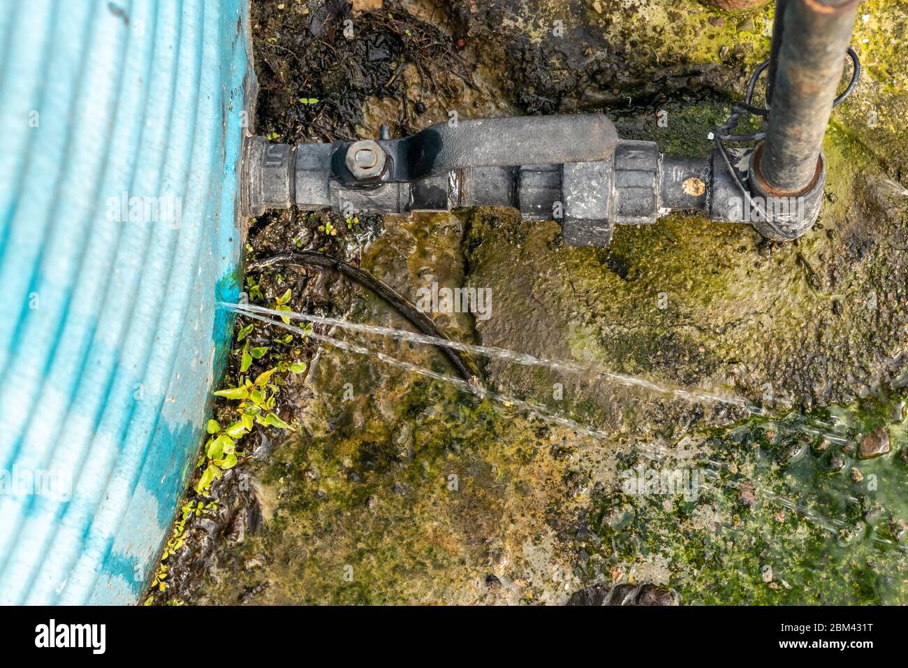 Fuite d'eau par la fissure dans le réservoir d'eau installé sur le toit de la maison. Banque D'Images