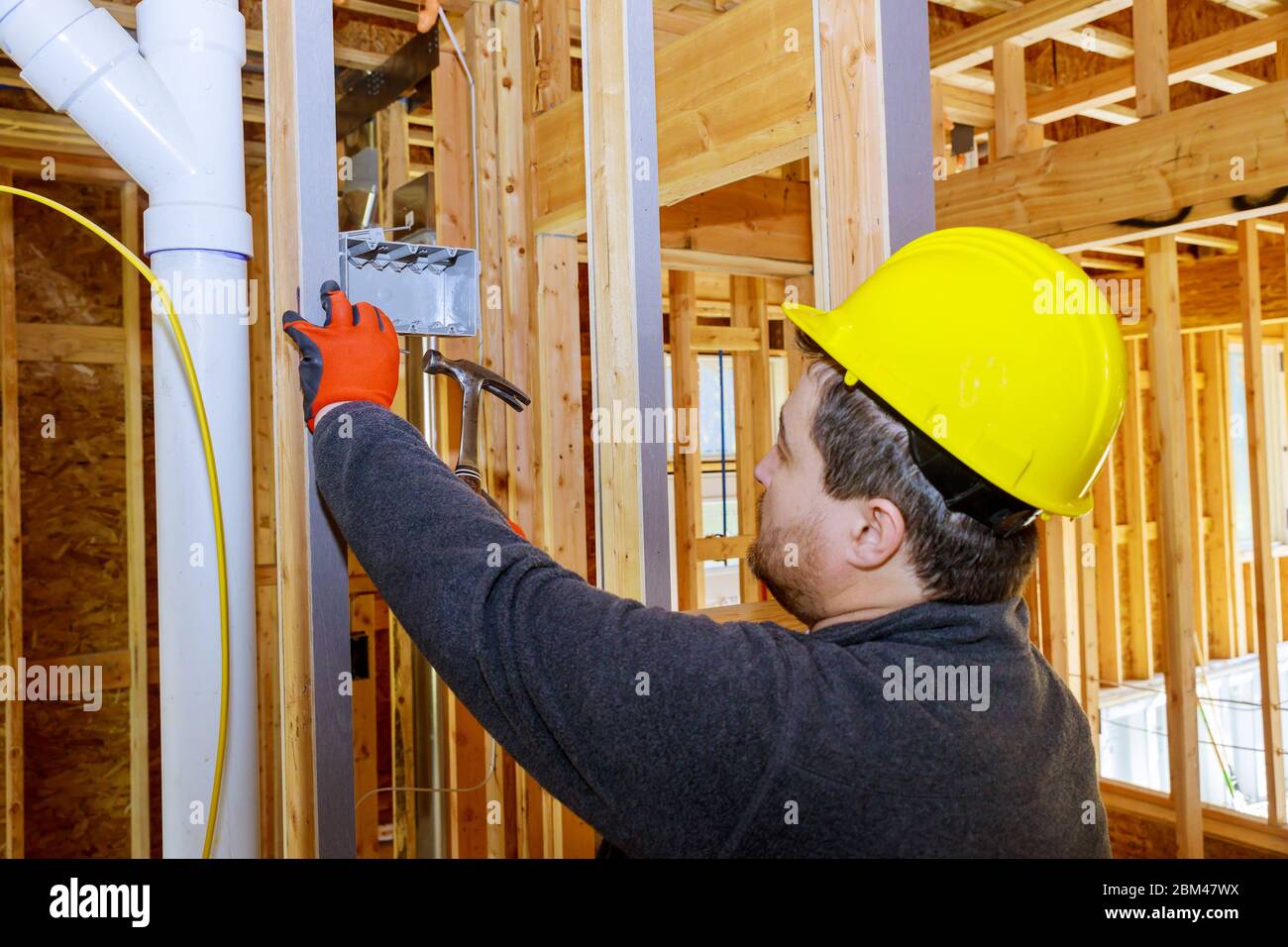 Mains d'électricien installant la prise électrique dans une nouvelle maison Banque D'Images