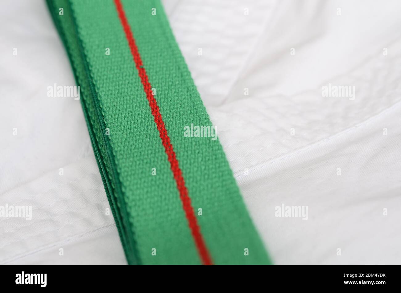 équipement de karaté : ceinture verte sur kimono sur fond clair Banque D'Images
