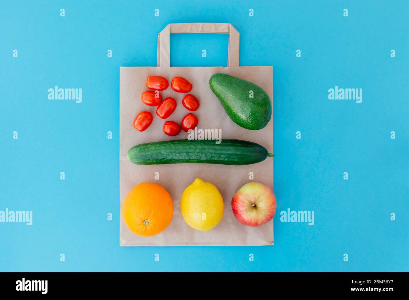 Fruits et légumes sur un sac en papier sur fond bleu. Concept alimentation saine. Livraison de nourriture, boutique en ligne. Acheter des produits en ligne pendant la quarantaine. Banque D'Images