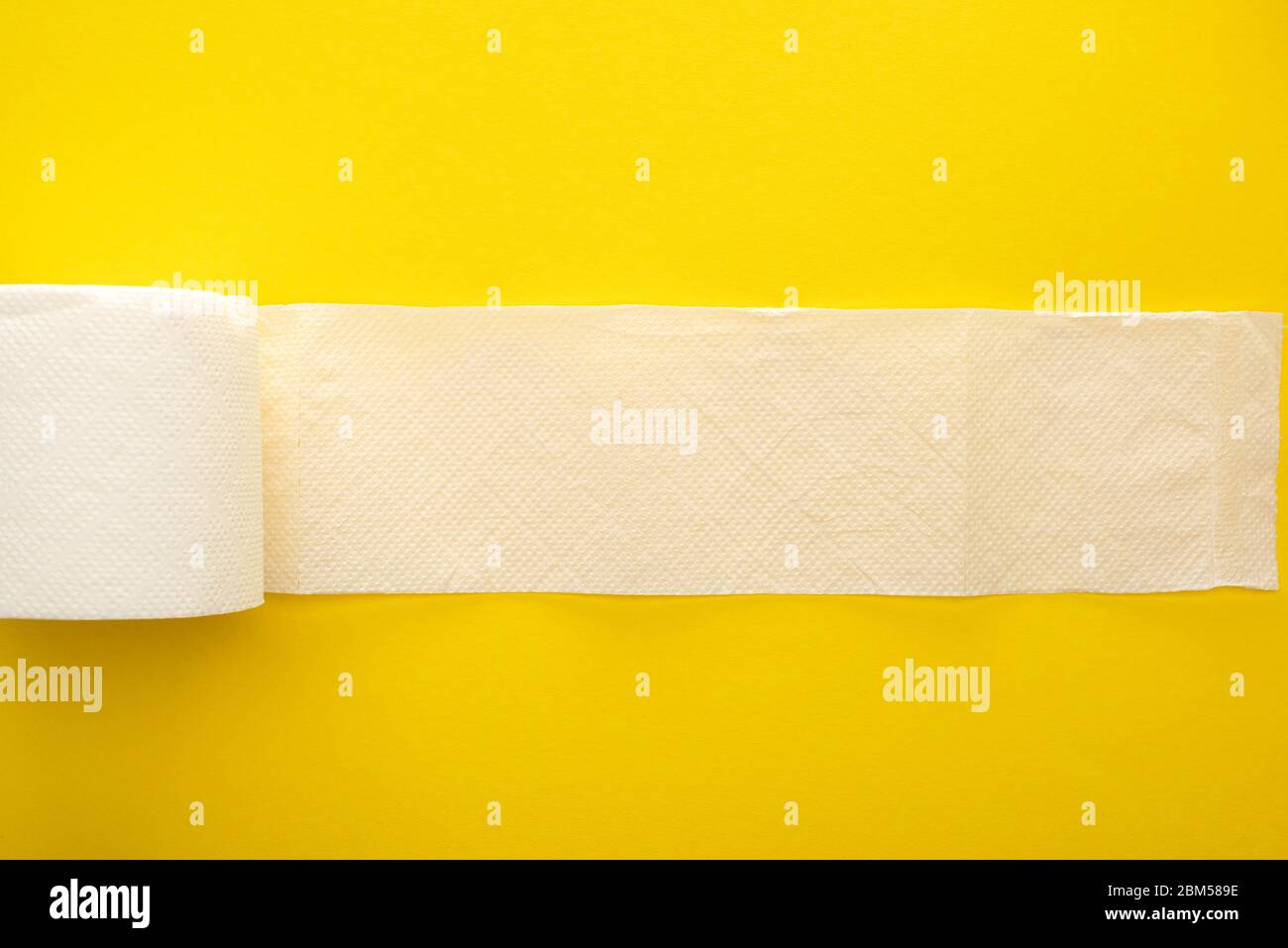 vue de dessus du papier toilette blanc non roulé sur fond jaune Banque D'Images