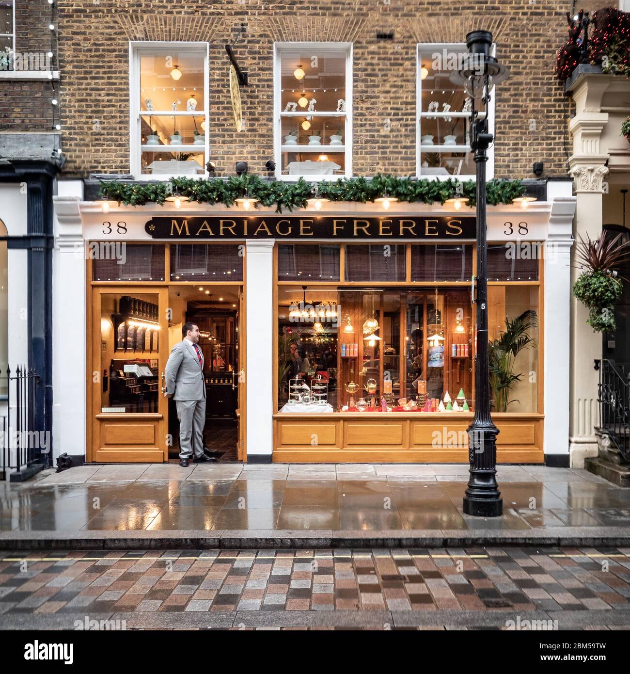 Boutique Mariage Freres, Covent Garden, Londres. Un acheteur de vente habillé avec élégance debout dans la porte d'un magasin de thé exclusif. Banque D'Images