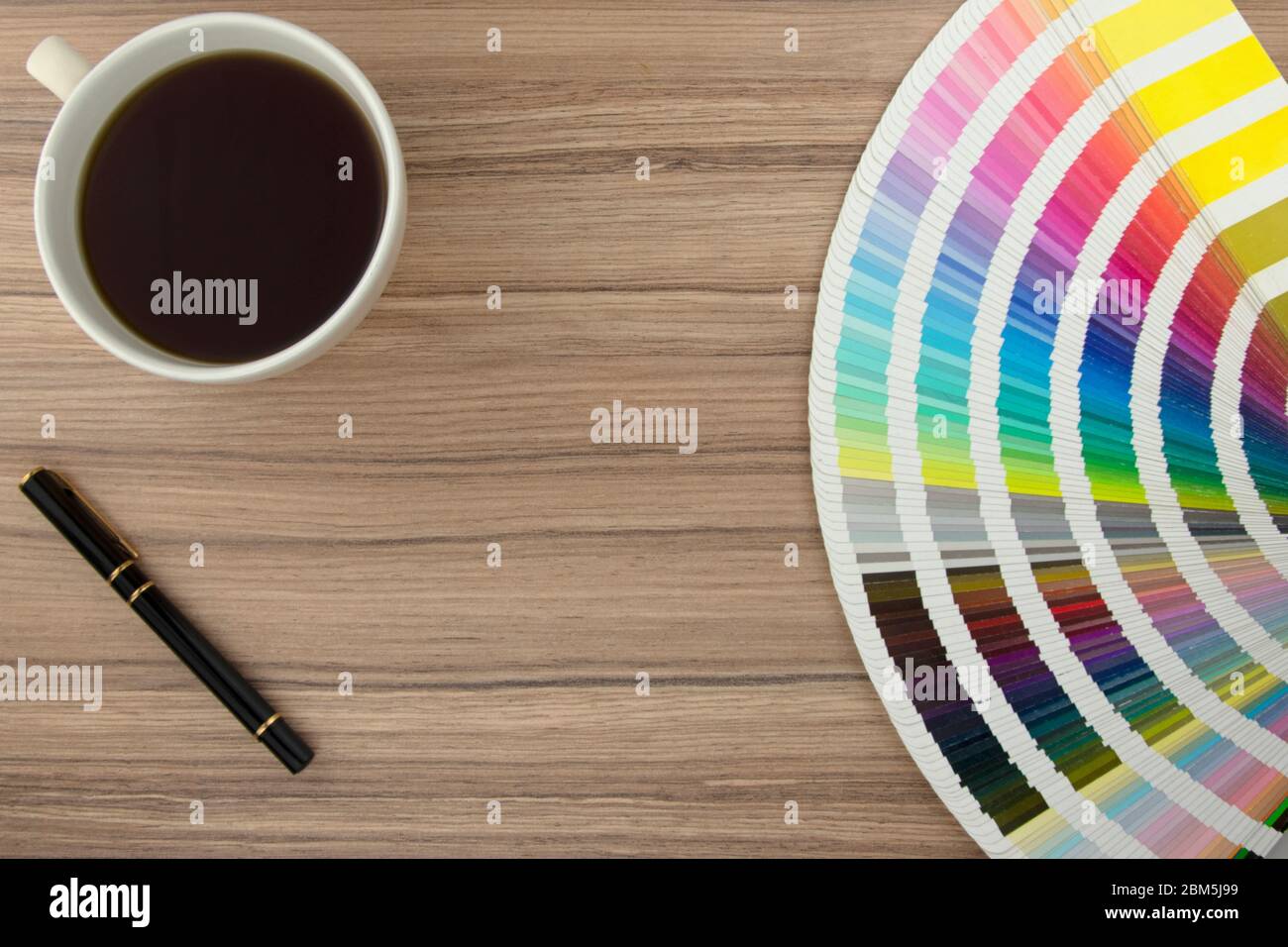 Gamme de cartes de couleurs sur un bureau en bois avec café et stylo Banque D'Images