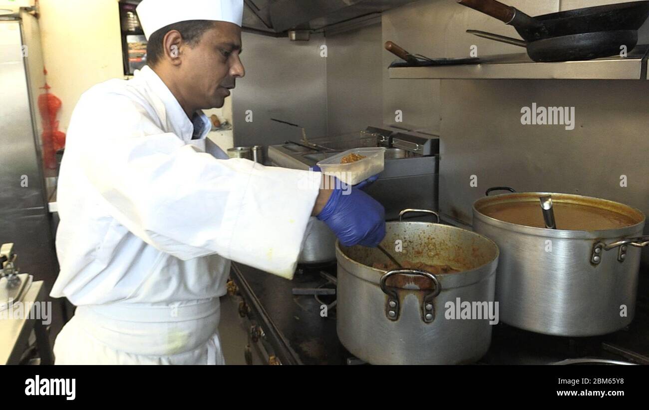 Le chef Muktar Ali prépare 250 curry au restaurant indien Vine, qui ont ensuite été envoyés au personnel de l'hôpital Royal Hallamshire dans le cadre de la semaine nationale de curry ChefOnline. L'initiative a été créée dans le but de fournir gratuitement plus de 25,000 000 repas aux travailleurs de la santé des hôpitaux du Royaume-Uni, alors qu'ils combattent l'épidémie de coronavirus. Banque D'Images