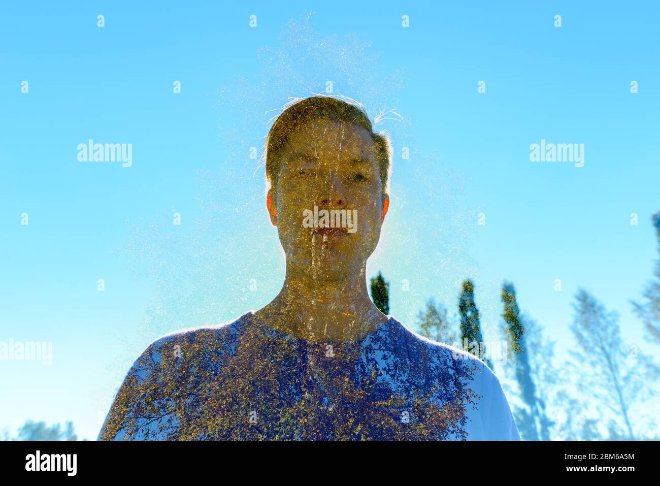 Exposition multiple de jeunes hommes beaux qui se superposent chêne et soleil contre ciel bleu Banque D'Images