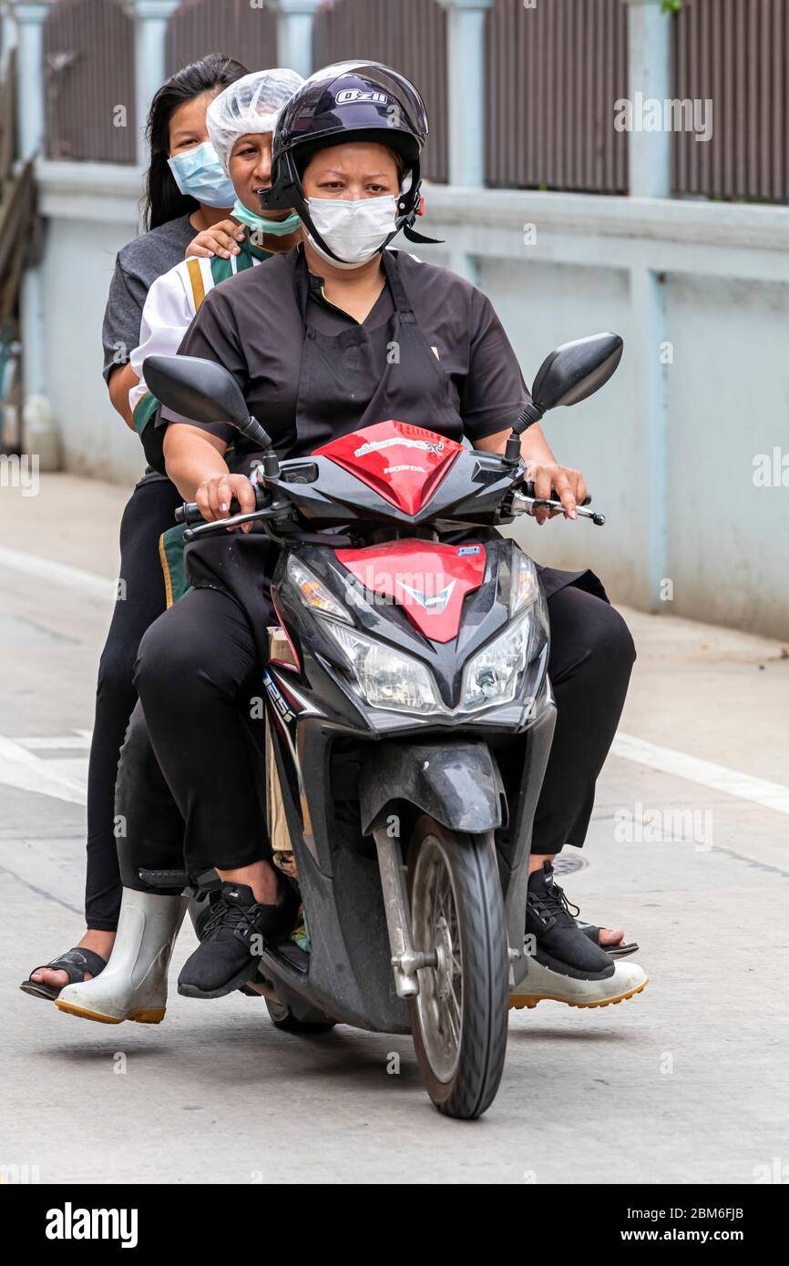 Trois filles avec masque de visage sur moto pendant la pandémie Covid 19, Bangkok, Thaïlande Banque D'Images