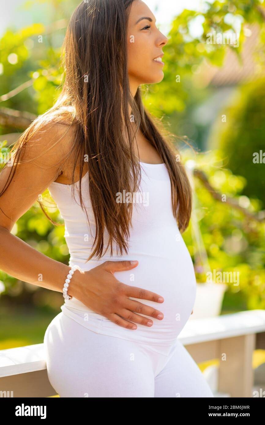 Une femme enceinte à été ourdoor holding hands on belly Banque D'Images