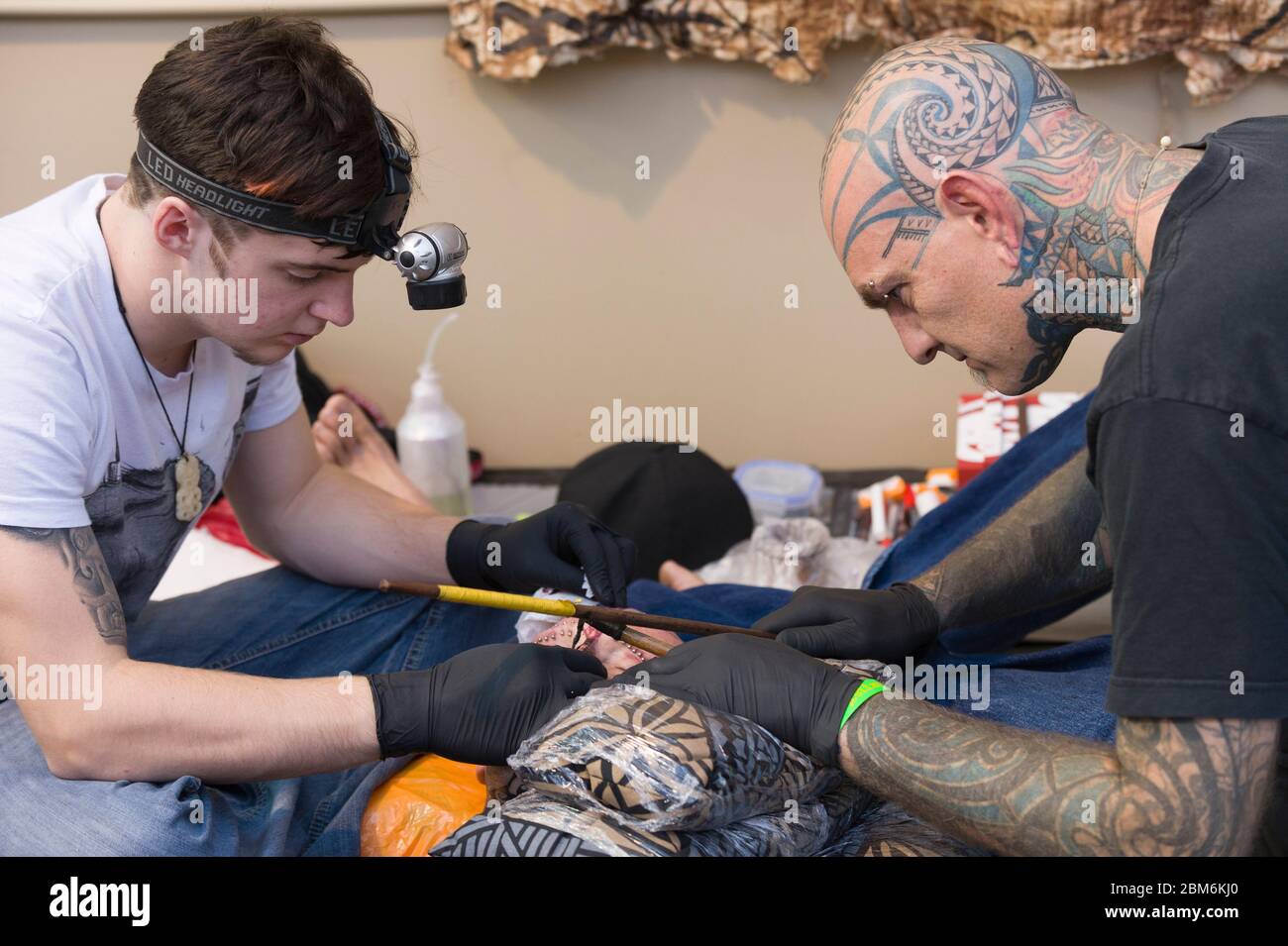 Homme ayant son visage tatoué par la méthode polynésienne. Cette méthode implique un peigne d'aiguilles qui est taraudé à la peau avec le bâton à la main. Le long Banque D'Images