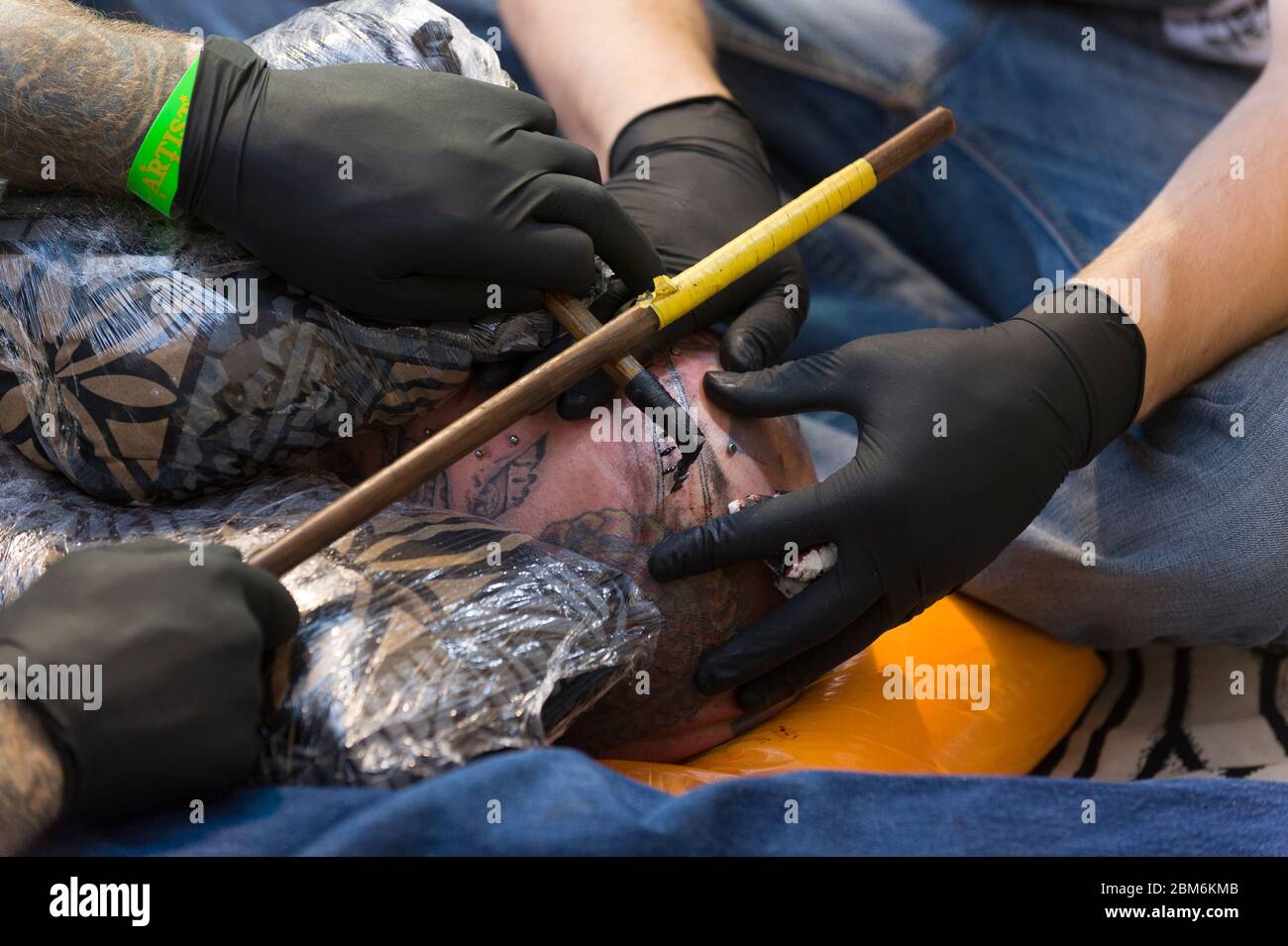 Homme ayant son visage tatoué par la méthode polynésienne. Cette méthode implique un peigne d'aiguilles qui est taraudé à la peau avec le bâton à la main. Le long Banque D'Images