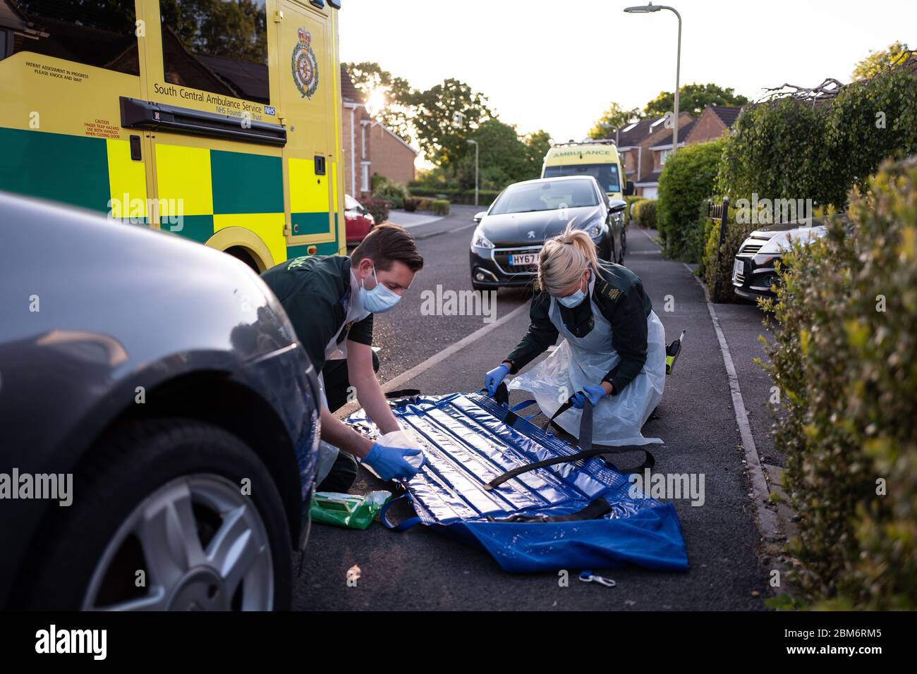 Une équipe d'ambulance portant des vêtements de protection désinfecte une Sling Southampton après l'avoir utilisée pour transporter une patiente de chez elle près de Portsmouth, Hampshire. Banque D'Images