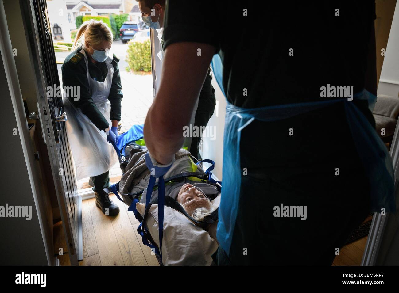 NOTE DE LA RÉDACTION : le patient a donné son consentement pour être photographié. Une équipe d'ambulance portant des vêtements de protection transporte une patiente dont l'état n'était pas lié à Covid-19, de son domicile dans une Sling de Southampton après avoir répondu à un appel de 999 à Portsmouth, Hampshire. Banque D'Images