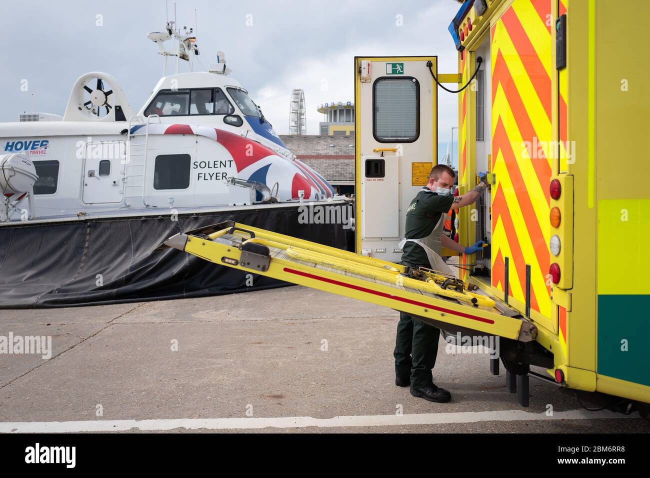 Un membre de l'équipage d'ambulance du South Central Ambulance Service charge un patient dans une ambulance près de Portsmouth, Hampshire, après qu'elle ait été transportée de l'île de Wight par aéroglisseur. Banque D'Images