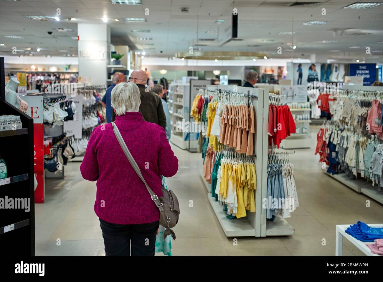 Les clients qui se font une queue dans le rayon vêtements de M&S en attendant les courses de nourriture Banque D'Images