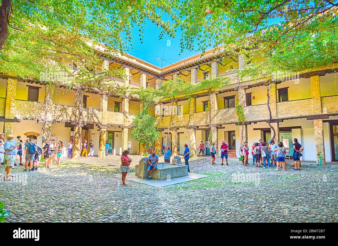 GRENADE, ESPAGNE - 25 SEPTEMBRE 2019 : la cour ombragée de Corral del Carbon (cour de charbon) avec une couverture naturelle de vignes, puits de pierre et brique arca Banque D'Images