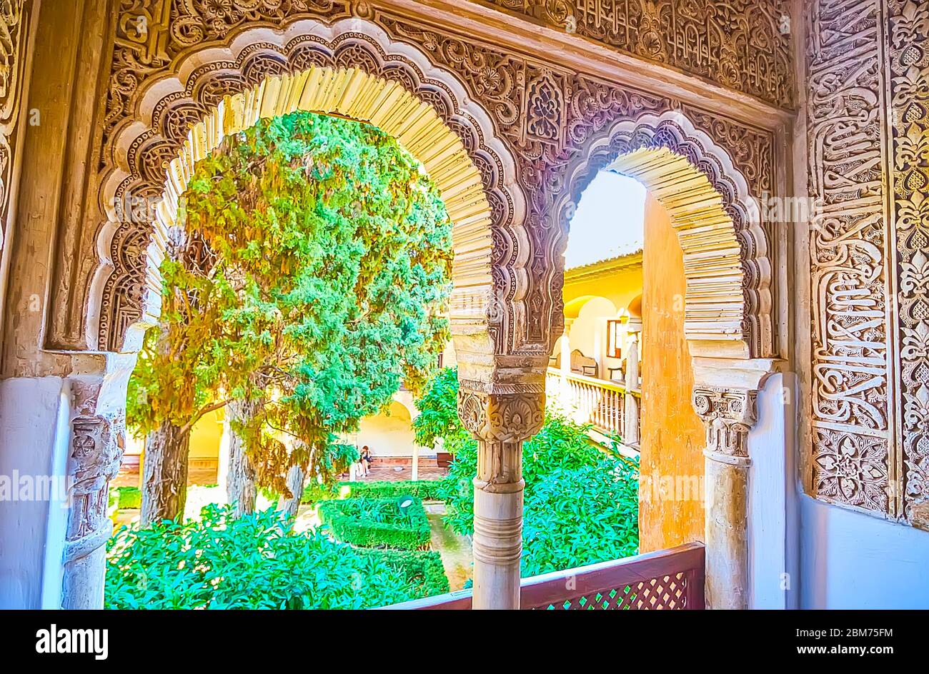 GRENADE, ESPAGNE - 25 SEPTEMBRE 2019 : le complexe de fenêtres voûtées sculptées dans le palais des Lions (palais Nasrid, Alhambra) ouvre la vue sur le vert luxuriant Daraxa Banque D'Images