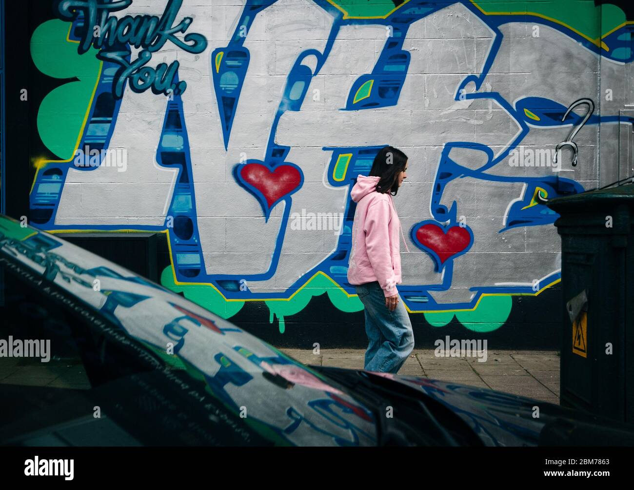 Une femme passe devant les graffitis et dit « Thankyou NHS », Glasgow, Écosse, pendant le confinement en cas de pandémie du virus Corona. Banque D'Images