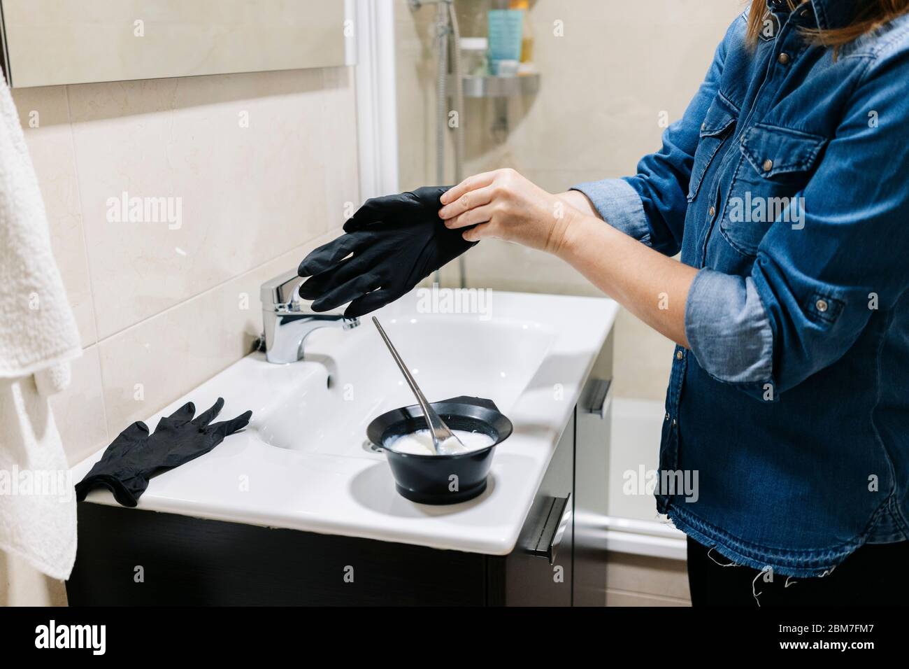 Une femme teint ses cheveux à la maison. Banque D'Images