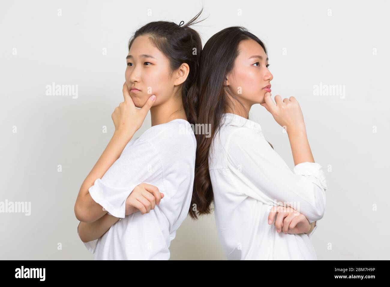 Deux jeunes femmes asiatiques magnifiques comme des amis pensant ensemble à l'arrière Banque D'Images