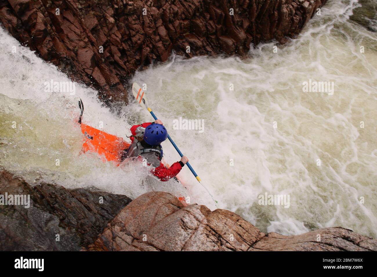 Femelle kayak de l'université pagayant au-dessus d'une cascade (Triple Step) dans un kayak Z-one sur la rivière Etive, Glen COE, Scottish Highlands, Écosse, Royaume-Uni Banque D'Images