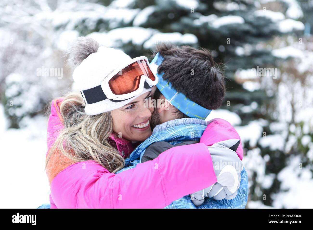 Couple heureux qui se tient sur des vacances de ski dans la neige Banque D'Images