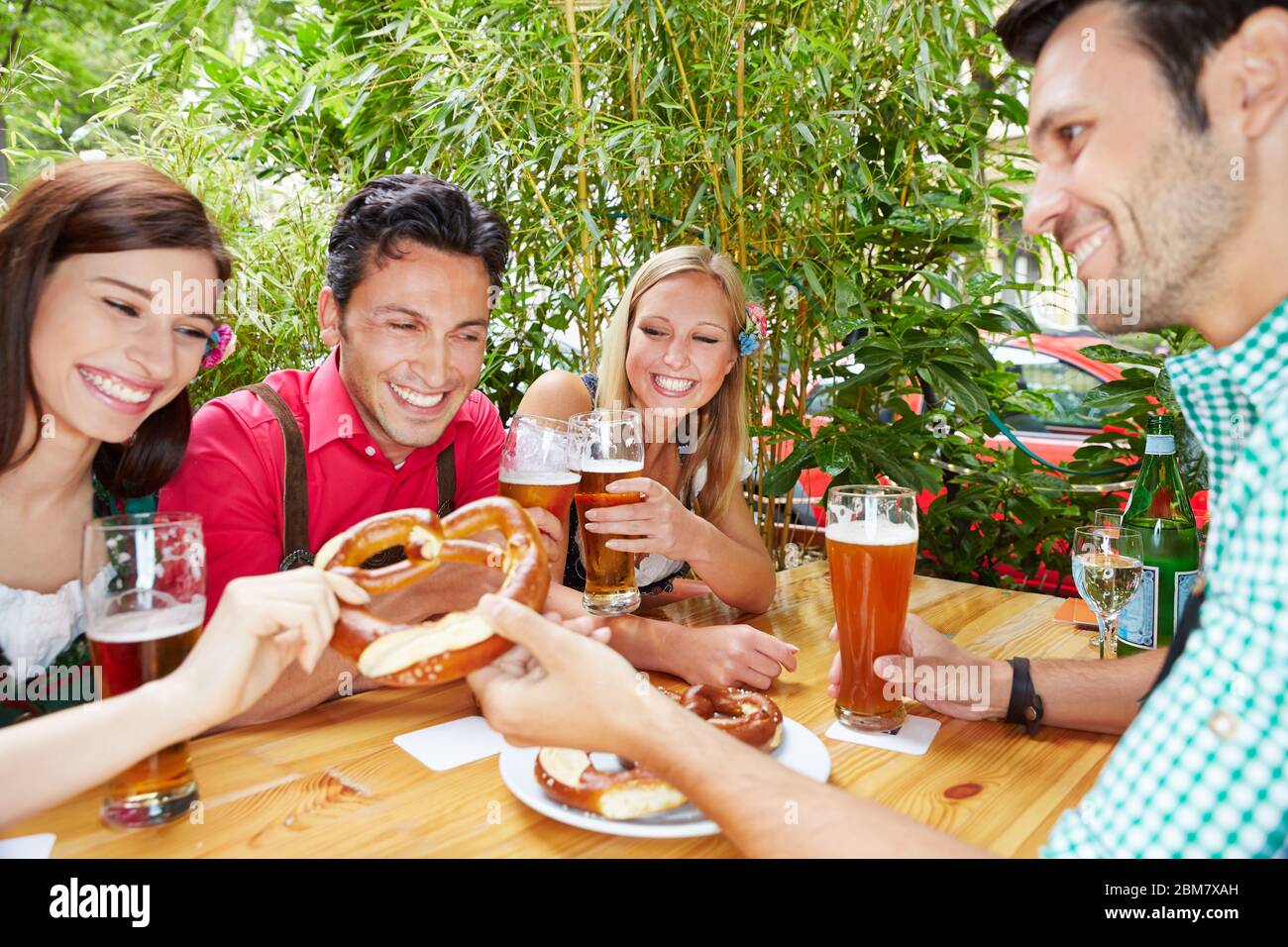 Groupe avec des rires de bière dans le jardin de bière en Bavière à l'Oktoberfest Banque D'Images