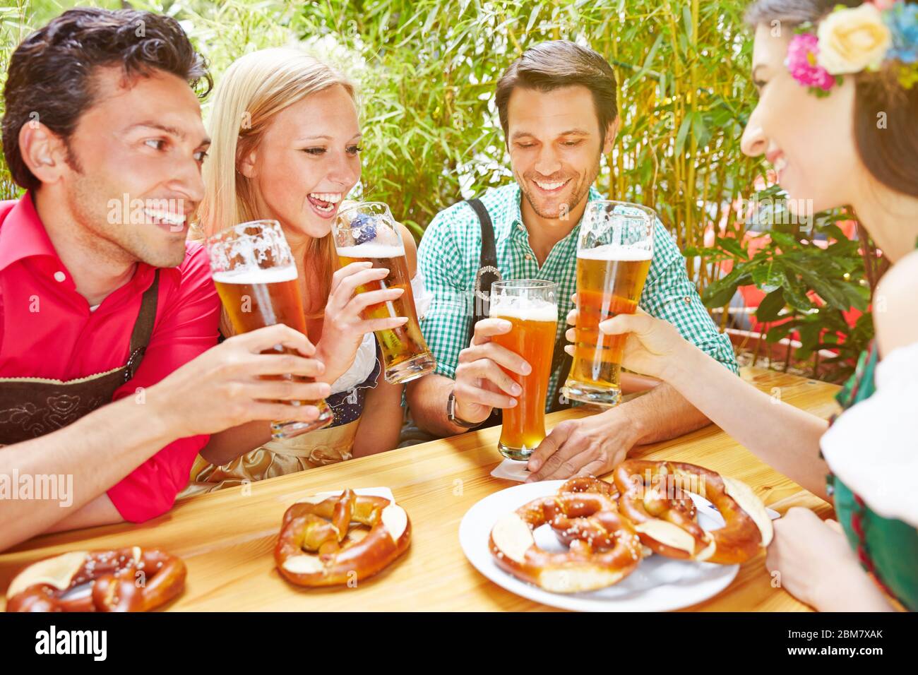 Groupe heureux de boire de la bière dans le jardin de bière en Bavière Banque D'Images