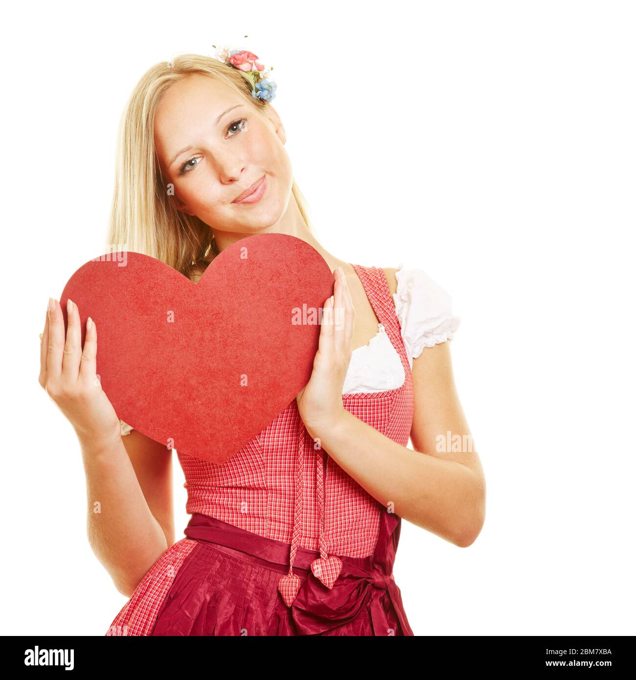 Jeune femme souriante dans dirndl avec un grand coeur rouge Banque D'Images