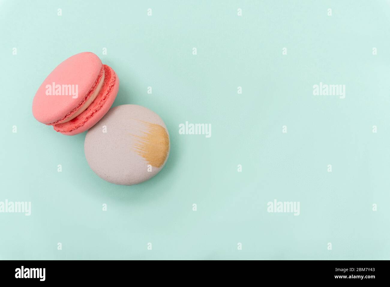Deux macarons ou macarons sont présents sur fond menthe ou turquoise, Banque D'Images