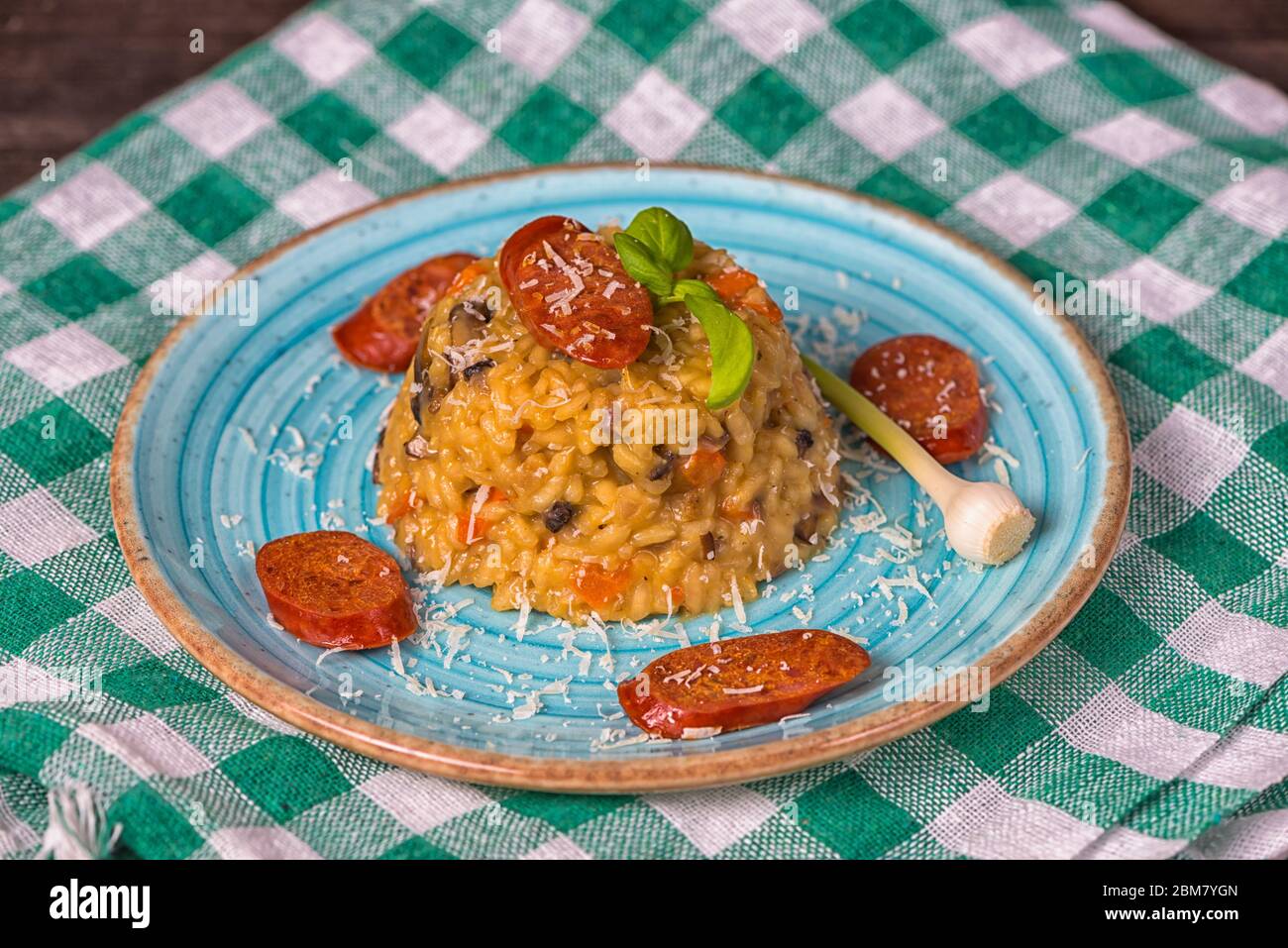 Rizotto chorizo parmesan ail assiette bleue ail Banque D'Images