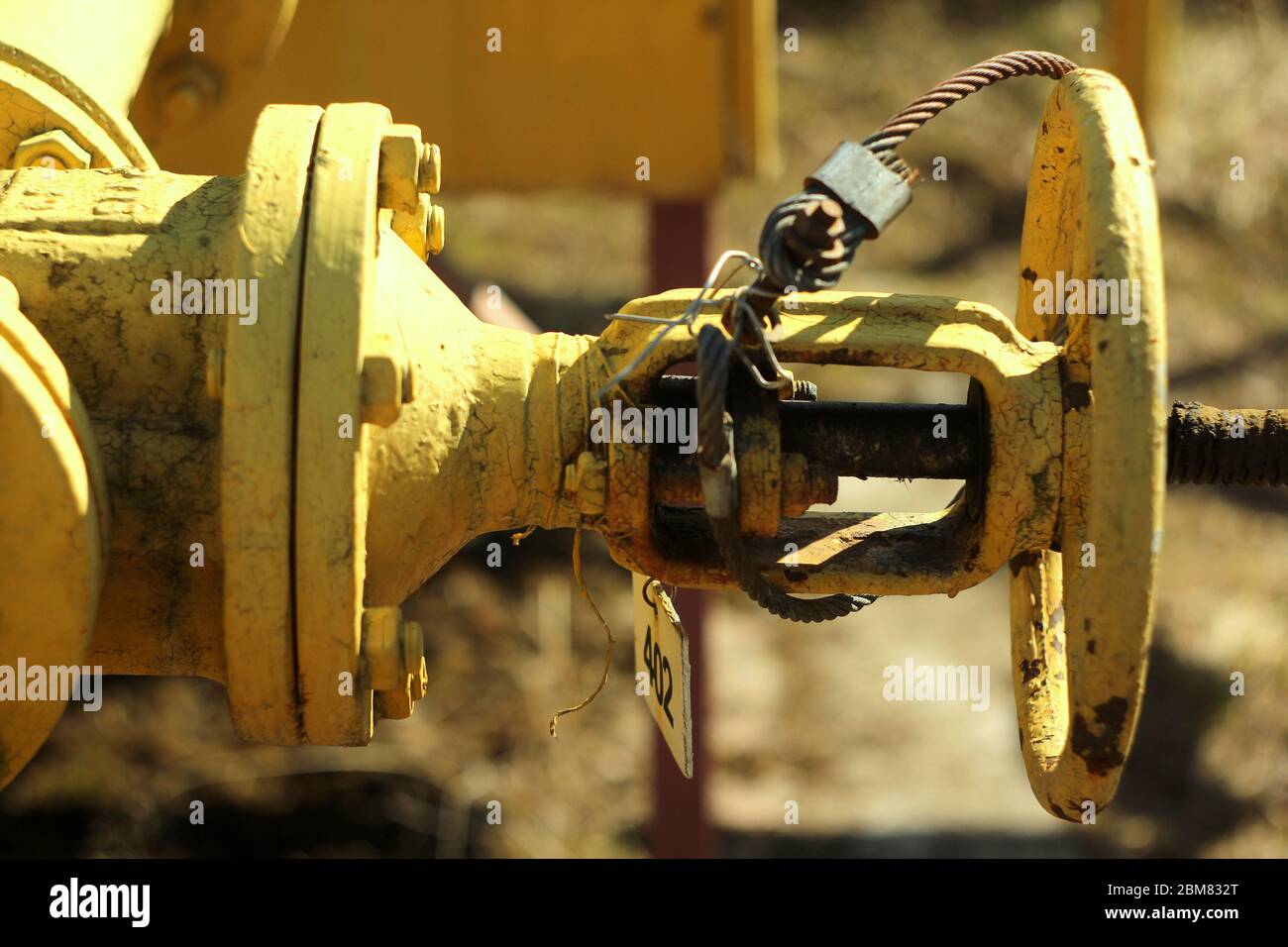 Un tuyau de gaz jaune avec une vanne ronde en Russie sur le fond d'un mur de bâtiment. Technologie industrielle du gazoduc. Banque D'Images