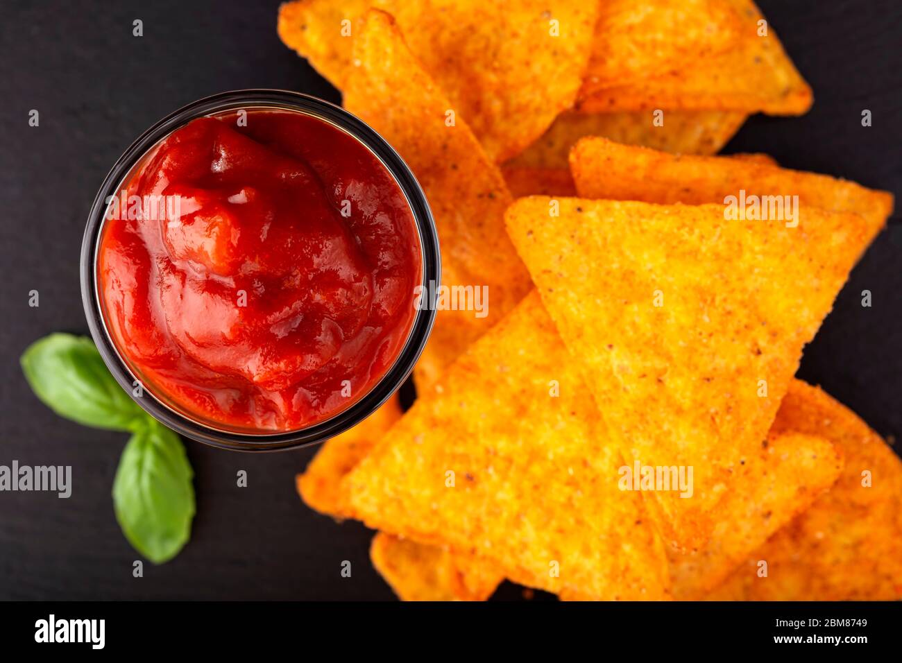 Croustilles tortilla et un bol en verre rempli de sauce salsa - vue de dessus Banque D'Images