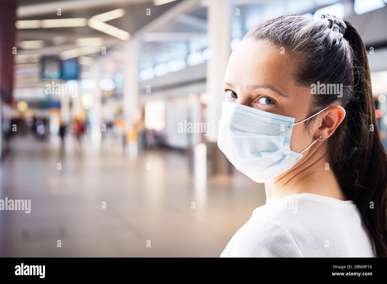 Femme en masque facial au terminal de l'aéroport en voyage Banque D'Images