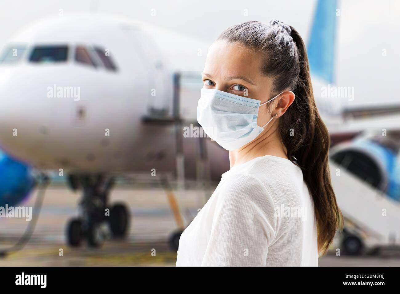 Femme voyageant dans le masque facial avant l'embarquement avion Banque D'Images