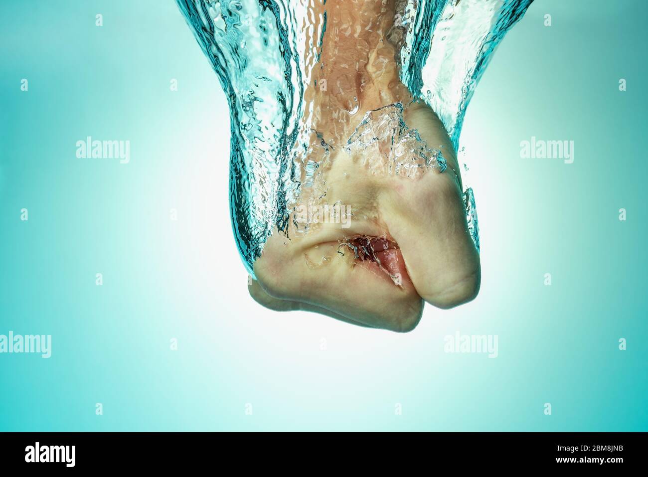 L'homme a frappé l'eau, le concept de force et de confiance en soi, l'assurance et le succès. Gros plan sur fond bleu Banque D'Images