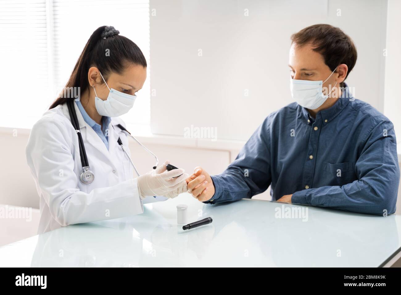 Médecin dans le masque de visage Vérification du taux de glucose de sang sucre Banque D'Images