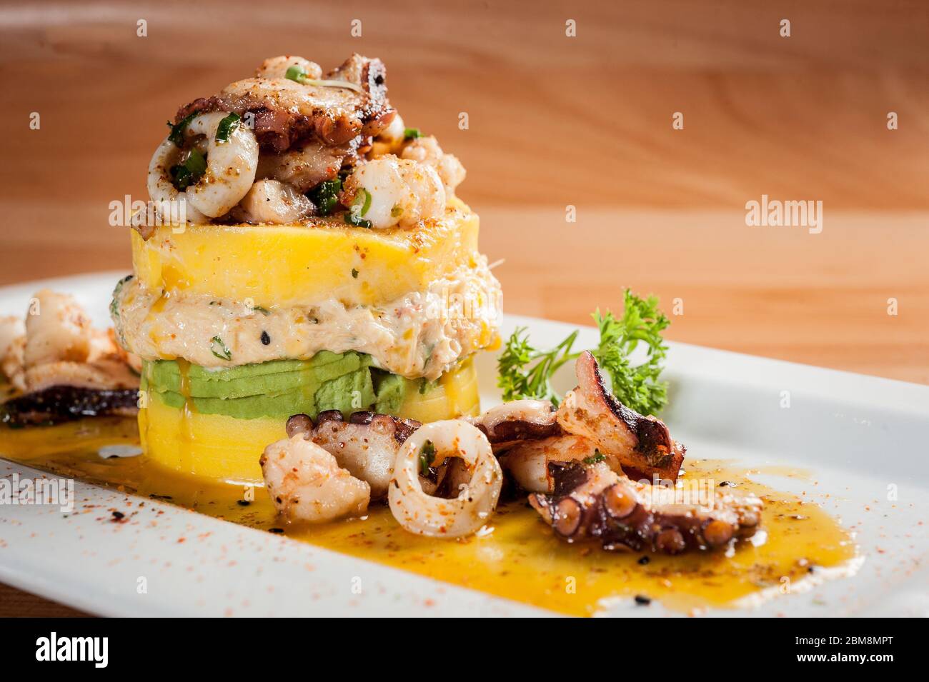 Plat péruvien traditionnel appelé Causa fait de purée de pommes de terre avec le piment et le jus de lime aji et rempli de légumes maïs, pois, carottes et Banque D'Images