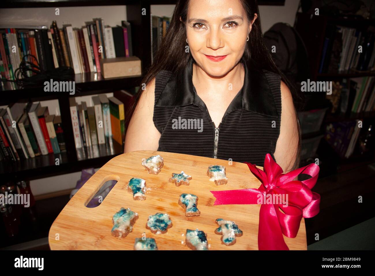 Femme caucasienne avec des yeux de couleur miel tenant dans ses mains plateau cadeau avec des biscuits de pain d'épice coupés en formes d'étoiles, buo, chat, fleur homme de pain d'épice Banque D'Images