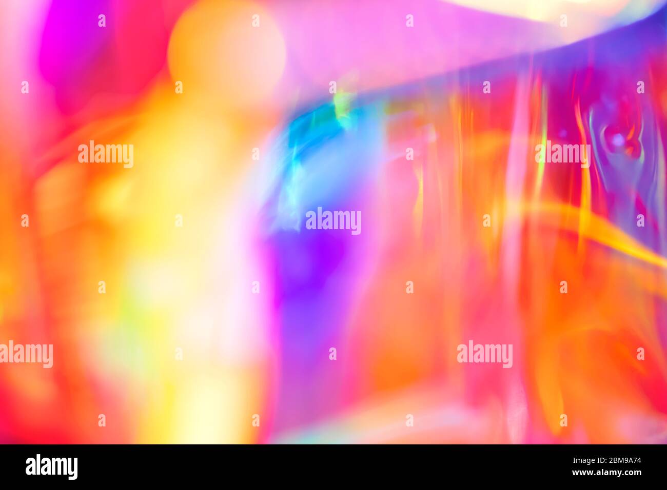 Abstrait holographique festif psychédélique pop fond de lignes fluides et tourbillons dans des couleurs vives de l'arc-en-ciel néon et lumière brillante Banque D'Images