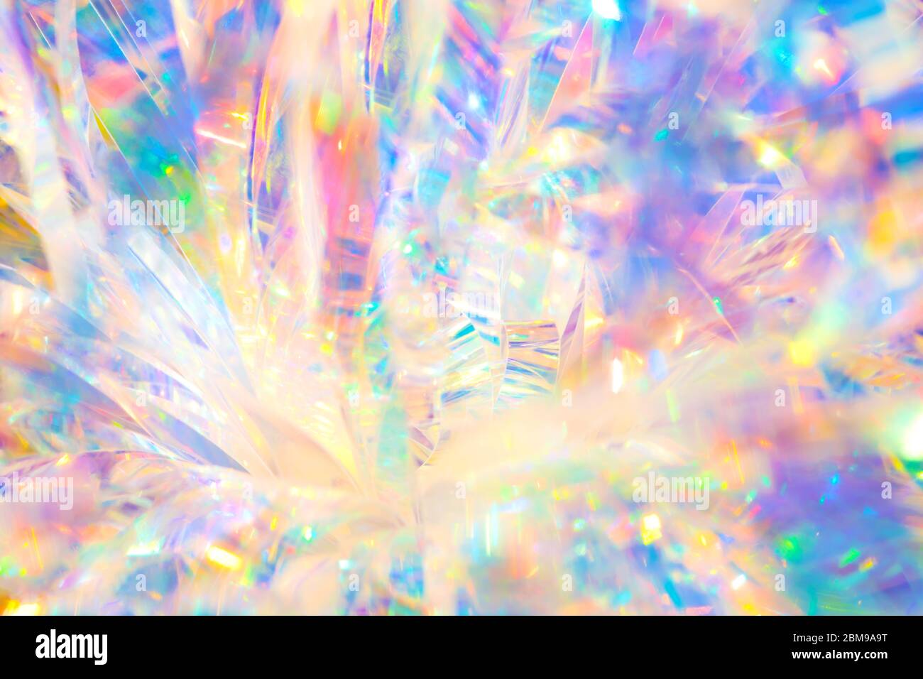 Abstrait rayonnant de fête joyeux Noël toile de fond image de texture holographique irisée de ruban de papier d'aluminium avec lumière vive et chaleureux et espar Banque D'Images